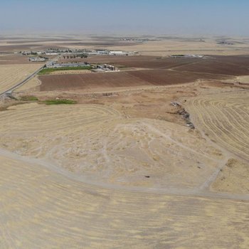 Asingrian: vista aerea del sito, sullo sfondo i rilievi meridionali della catena degli Zagros